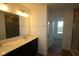 Bright bathroom featuring a double sink vanity, large mirror, and a separate shower at 10138 Redwood Peak Ln, Indianapolis, IN 46259