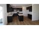 Modern kitchen features dark wood cabinetry, island, stainless steel appliances, and hardwood floors at 10138 Redwood Peak Ln, Indianapolis, IN 46259