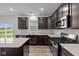 Modern kitchen featuring stainless steel appliances, granite countertops, and dark wood cabinetry at 10138 Redwood Peak Ln, Indianapolis, IN 46259
