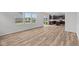 Open-concept living space with wood-look flooring and plenty of natural light, flowing into a kitchen area at 10138 Redwood Peak Ln, Indianapolis, IN 46259