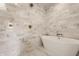 Serene bathroom with a freestanding tub, marble tiling, and modern fixtures at 10415 Westfield Blvd, Carmel, IN 46280