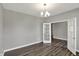 Dining room with gray walls, modern flooring, and open french doors to another living area at 10423 Hamburg Dr, Fortville, IN 46040