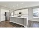 Bright kitchen features a large island, stainless steel appliances, white cabinetry, and hardwood flooring at 10423 Hamburg Dr, Fortville, IN 46040