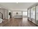 Open-concept living space with hardwood floors showcasing the kitchen with stainless steel appliances and a large island at 10423 Hamburg Dr, Fortville, IN 46040