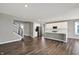 Open-concept living space with a staircase and hardwood floors showcasing the kitchen with stainless steel appliances at 10423 Hamburg Dr, Fortville, IN 46040