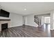 Open living room with hardwood floors, a fireplace, and staircase leading to upper level at 10423 Hamburg Dr, Fortville, IN 46040