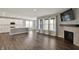 Spacious living room with a modern fireplace, tv, and hardwood floors with an open view of the kitchen at 10423 Hamburg Dr, Fortville, IN 46040