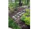 Stone pavers create a meandering path through a beautifully landscaped backyard, offering an invitation to stroll through nature at 10561 Wilson Rd, Brownsburg, IN 46112