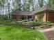 Large backyard with lush lawn, established gardens, stone pathways, and a brick house at 10561 Wilson Rd, Brownsburg, IN 46112