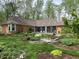 Expansive backyard with a well-manicured lawn, vibrant garden beds, and a picturesque wooden bridge over a stone creek at 10561 Wilson Rd, Brownsburg, IN 46112