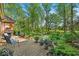 Backyard patio with chairs and grill, overlooking lush greenery and mature trees at 10561 Wilson Rd, Brownsburg, IN 46112