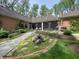 Expansive backyard showcasing a stone pathway, lush garden beds, and a brick home with a screened-in porch at 10561 Wilson Rd, Brownsburg, IN 46112