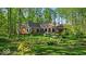 Brick home with landscaped backyard featuring mature trees, patio, and lush lawn at 10561 Wilson Rd, Brownsburg, IN 46112