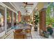 Covered patio with tile floors, brick columns, ceiling fans, and outdoor dining area at 10561 Wilson Rd, Brownsburg, IN 46112