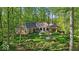 A terracotta colored house with manicured lawns surrounded by a forest of mature shade trees at 10561 Wilson Rd, Brownsburg, IN 46112