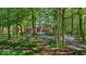 A terracotta colored home nestled among mature shade trees with a long driveway at 10561 Wilson Rd, Brownsburg, IN 46112