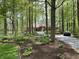View of a single story home with a brick exterior, surrounded by mature trees and front yard landscaping at 10561 Wilson Rd, Brownsburg, IN 46112