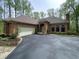View of a single story home with a brick exterior, attached garage, driveway and manicured landscaping at 10561 Wilson Rd, Brownsburg, IN 46112