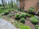 A beautifully landscaped garden bed along a brick home exterior, with a variety of plants and a stone pathway at 10561 Wilson Rd, Brownsburg, IN 46112