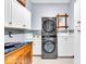 Laundry room features a stacked washer and dryer with storage space and tiled backsplash at 10561 Wilson Rd, Brownsburg, IN 46112