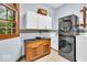 Well-lit laundry room with a modern stacked washer/dryer and ample storage at 10561 Wilson Rd, Brownsburg, IN 46112