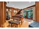 Well-decorated living room showcasing wood floors, a piano, built-in shelving, and outdoor access at 10561 Wilson Rd, Brownsburg, IN 46112