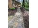 Stone walkway beside home and mature trees offering a beautifully designed outdoor space to enjoy the natural surroundings at 10561 Wilson Rd, Brownsburg, IN 46112