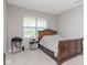 Cozy bedroom with a wooden bed frame, neutral carpet, and natural light from the window at 10810 Arendale Dr, Brownsburg, IN 46112