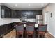 Modern kitchen with dark cabinetry, stainless steel appliances, and breakfast bar seating for casual dining at 10810 Arendale Dr, Brownsburg, IN 46112