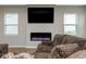 Comfortable living room featuring a modern fireplace, large TV, and plush sofa for relaxing and entertaining at 10810 Arendale Dr, Brownsburg, IN 46112
