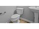 Small powder room features a white toilet and pedestal sink with a modern chrome faucet at 1114 Ridgevine Rd, Greenwood, IN 46143