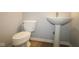 A clean half bathroom with a white toilet and pedestal sink against neutral walls at 1114 Ridgevine Rd, Greenwood, IN 46143