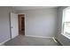 A quiet bedroom offers neutral carpet, paint, and a window that offers ample natural light at 1114 Ridgevine Rd, Greenwood, IN 46143