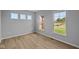 Bright bedroom with modern wood flooring and abundant natural light from three windows at 1114 Ridgevine Rd, Greenwood, IN 46143