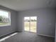 Carpeted bedroom featuring a large sliding glass door and a bright window with a view of the neighborhood at 1114 Ridgevine Rd, Greenwood, IN 46143