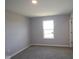 A carpeted bedroom features neutral colors and ample natural light from one window at 1114 Ridgevine Rd, Greenwood, IN 46143