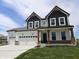 Two-story home showcasing a three-car garage and stylish black and white color scheme at 1114 Ridgevine Rd, Greenwood, IN 46143