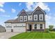 Striking two-story home with a three car garage, craftsman details and a well-manicured lawn at 1114 Ridgevine Rd, Greenwood, IN 46143