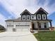 Two-story home showcasing a three-car garage and stylish black and white color scheme at 1114 Ridgevine Rd, Greenwood, IN 46143