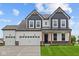Striking two-story home with a three car garage, craftsman details and a well-manicured lawn at 1114 Ridgevine Rd, Greenwood, IN 46143