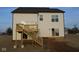 A new build with a white exterior features a wood deck and stairs leading to a sliding glass door entry at 1114 Ridgevine Rd, Greenwood, IN 46143