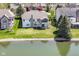 Expansive backyard featuring a deck, screened-in porch, well-maintained lawn, and waterfront access to a serene pond at 11862 Stoney Bay Cir, Carmel, IN 46033