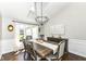 Bright dining room with dark wood floors, a large window, and a modern chandelier at 11862 Stoney Bay Cir, Carmel, IN 46033
