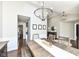 Bright dining room with dark wood floors, a large chandelier, and a view into the living room at 11862 Stoney Bay Cir, Carmel, IN 46033