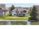 Aerial view of the backyard showing the house with a screened porch next to a scenic pond at 11862 Stoney Bay Cir, Carmel, IN 46033