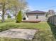 Home with a wooden deck, patio area, neutral vinyl siding, a small lawn, and trees at 125 W Noble St, Lebanon, IN 46052