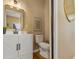 A well-decorated half bathroom with a white vanity, toilet, mirror and art at 125 W Noble St, Lebanon, IN 46052