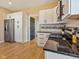 An open kitchen with stainless steel appliances, white cabinets, black countertops and wood-look floors at 125 W Noble St, Lebanon, IN 46052