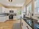 A bright kitchen with stainless steel appliances, white cabinets, black countertops and wood-look floors at 125 W Noble St, Lebanon, IN 46052
