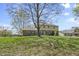 Spacious backyard with a large tree, beautiful lawn, and a view of the home's exterior and adjacent properties at 12867 Andover Dr, Carmel, IN 46033